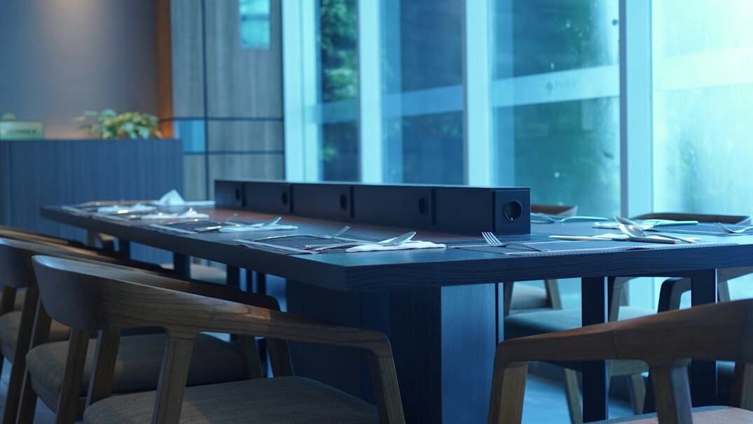 Conference room table with documents and a laptop